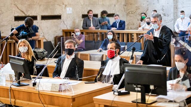 Mehrere Personen mit Atemschutzmasken in einem Gerichtssaal.