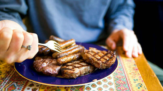 Ein Teller mit Steaks und Grillwürstchen.