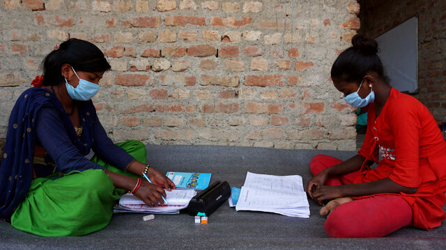 Zwei Mädchen sitzen auf dem Boden und lernen