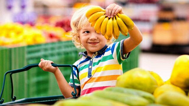 Ein Kind hält Bananen in die Luft