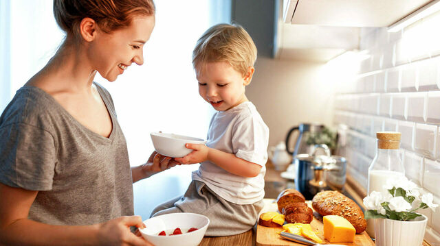 Mutter mit Kind beim Frühstück in der Küche