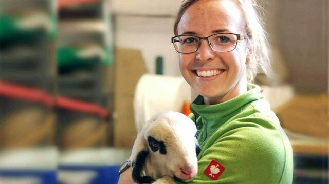 Landwirtin Elisa Hartung hält ein Lamm auf dem Arm