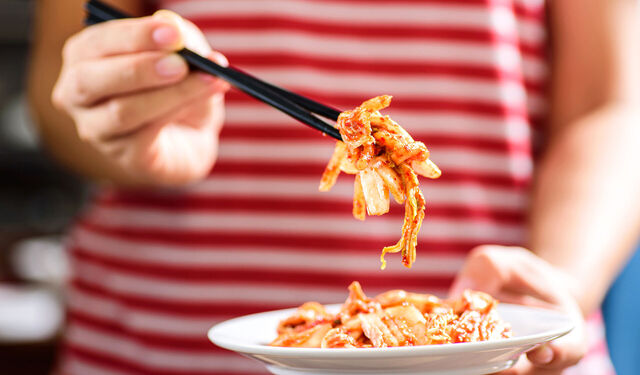 Fermentiertes Kimchi-Gemüse wird mit Stäbchen gegessen